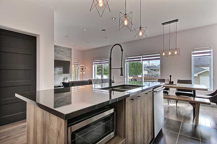 Grand îlot de cuisine et luminaires modernes suspendus